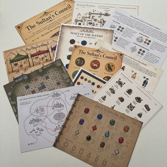 A set of printed game cards and rule sheets for a fantasy board game, including 'The Sultan's Council', 'Seals of the Sultan', and 'The Crystal Casket', arranged on a light-colored surface.