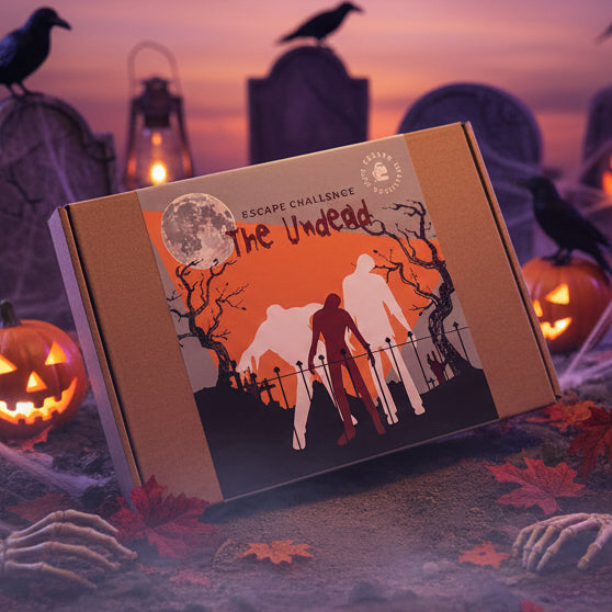 Halloween-themed zombie escape room challenge kit box in a graveyard with pumpkins and crows in the background